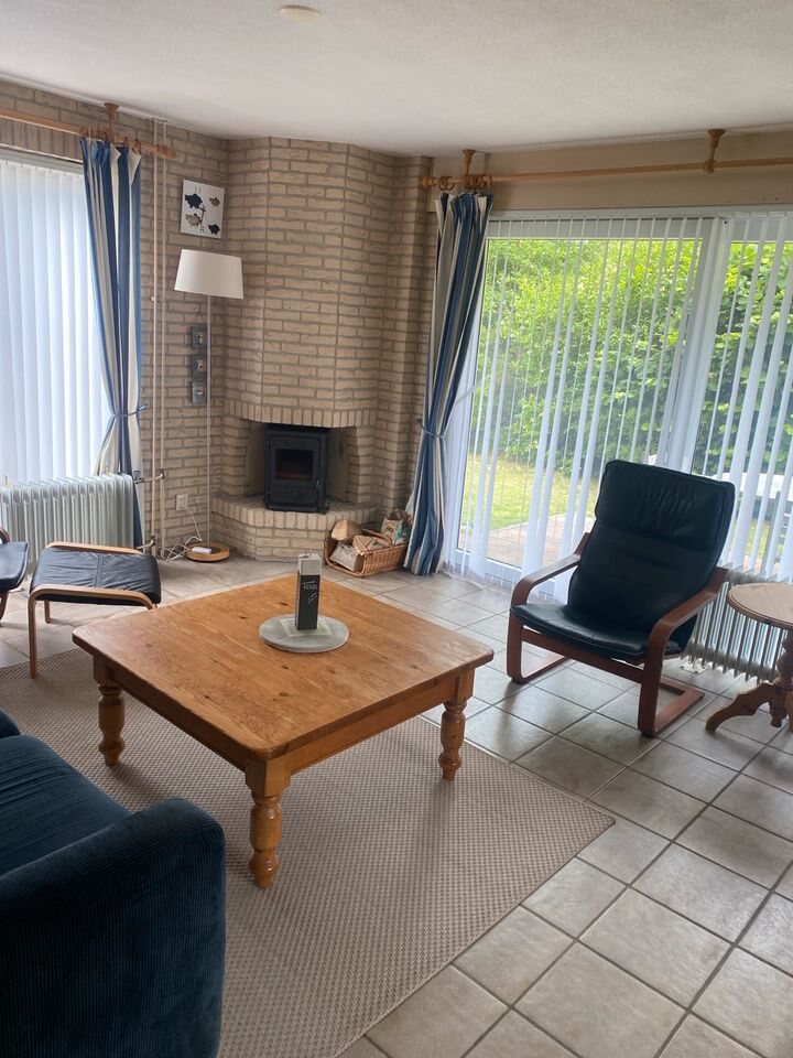Wohnbereich mit Couchtisch, Sesseln und Eckkamin