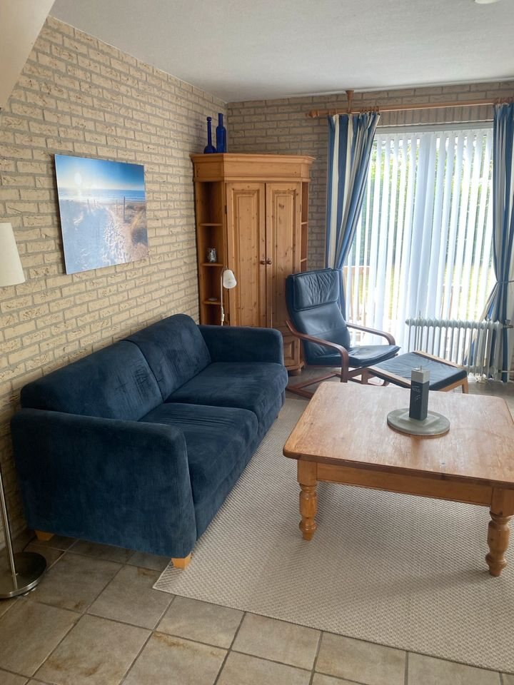 Blaues Sofa, Holztisch und Kiefernschrank